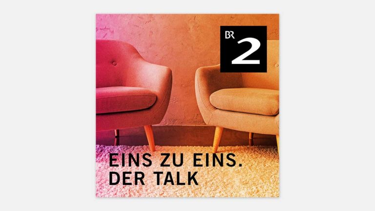 Zwei Sessel, das Logo von „Eins zu Eins. Der Talk“